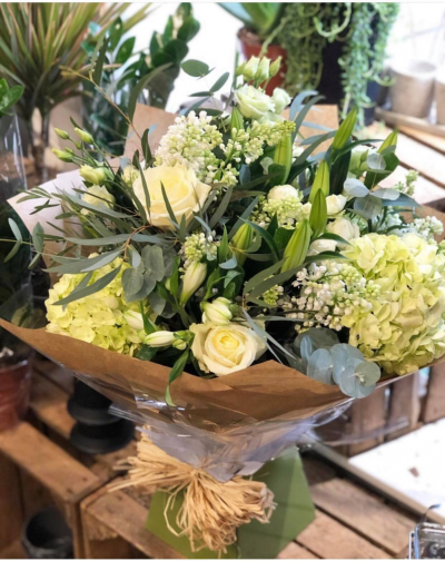 Elegant White Hand Tied - A beautifully arranged hand tied bouquet filled with white and green flowers. Flowers may include roses, lilies, spray roses, lisianthus, alstromeria and hydrangea. 